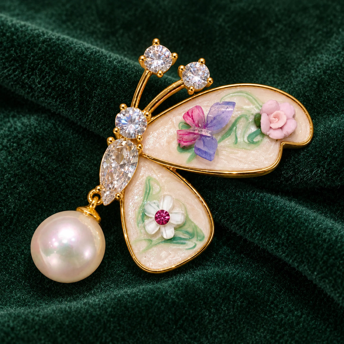 Kielo’s two floral wings and pearl-look drop displayed on forest-green velvet.