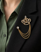 Kruunu Openwork Crown Lapel Chain Brooch in gold-tone finish; close wearing view on a structured lapel