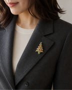Close wearing view of the small Multicolor Kuusi brooch inside a charcoal blazer lapel.