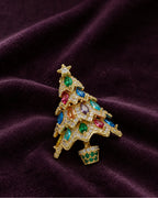 Multicolor Kuusi brooch resting on deep plum fabric.