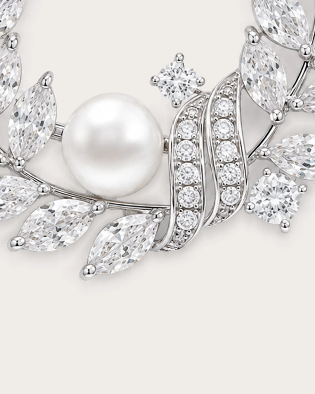 Laurea close detail of the freshwater pearl and curved stone-set ribbons on the silver wreath brooch.