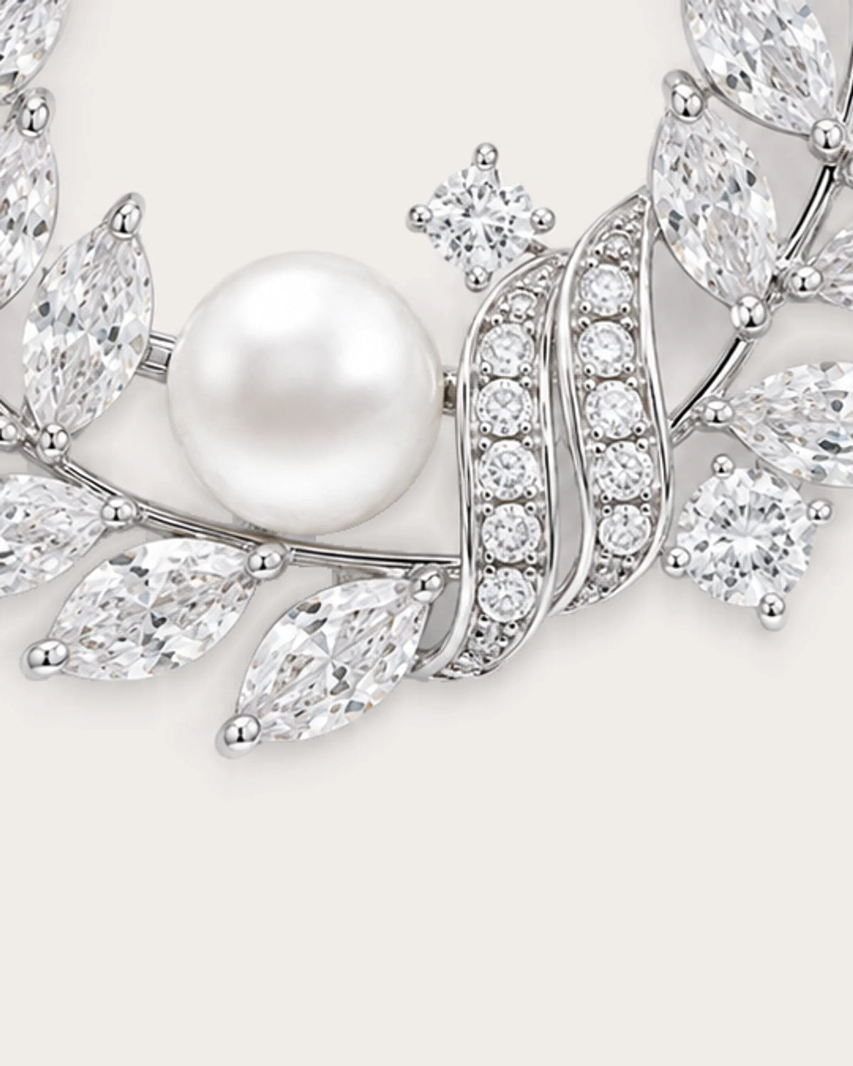 Laurea close detail of the freshwater pearl and curved stone-set ribbons on the silver wreath brooch.