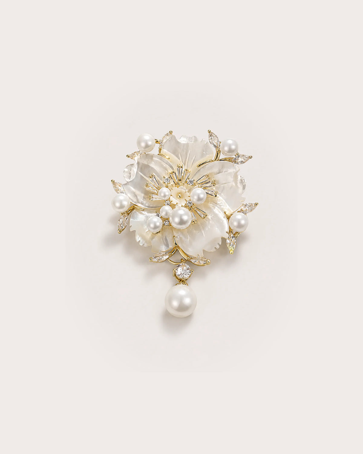 Linnea Pearl Shell Flower Brooch on a warm pale studio background with a natural contact shadow