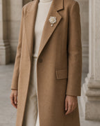 Wide styling view showing the true 4.5 by 6.0 centimetre scale of Linnea Brooch on a camel coat lapel