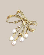 Reverse of the bow brooch showing its real hinged pin, catch and five pearl drops