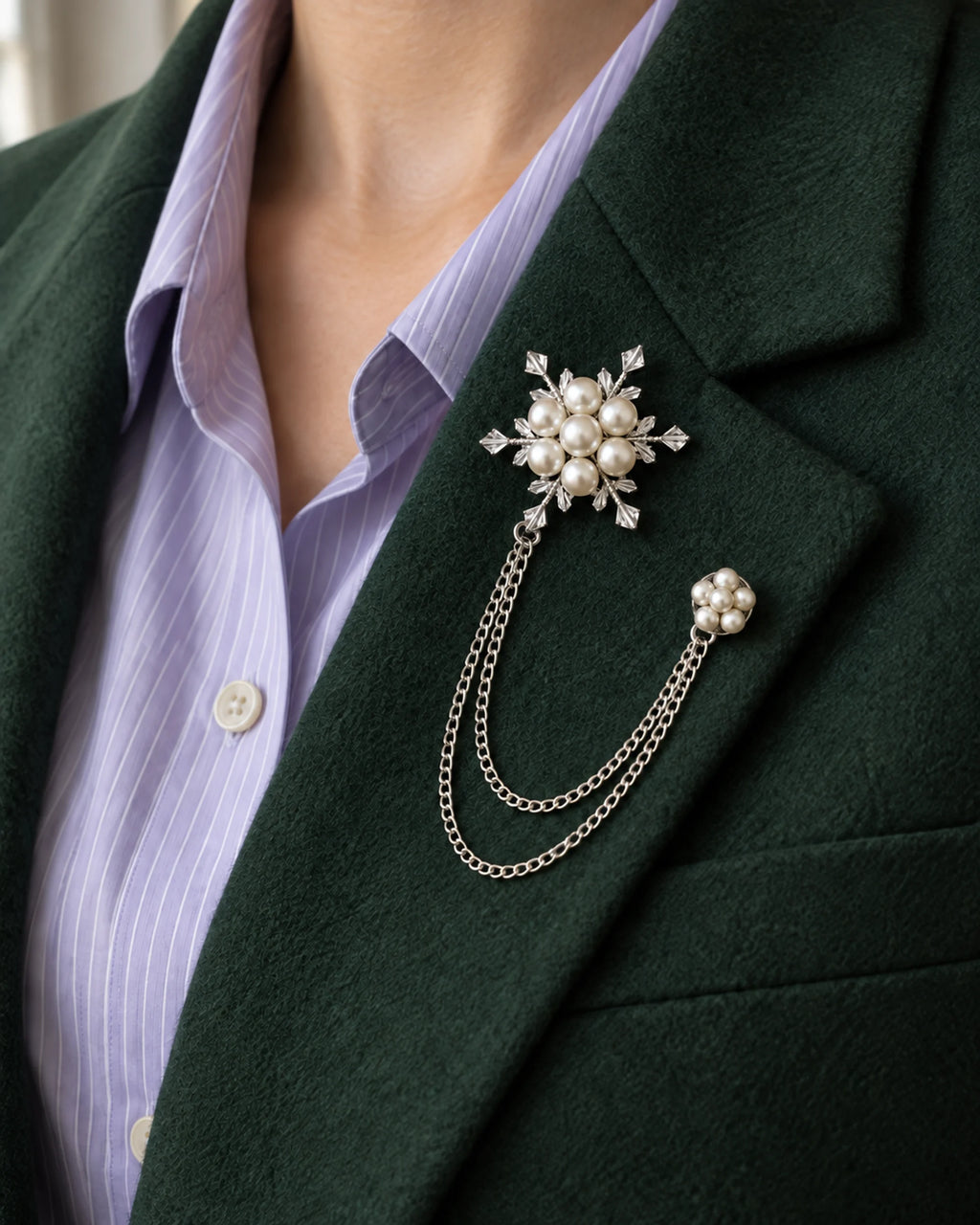 Lume Snowflake Lapel Chain Brooch in silver-tone finish; close wearing view on a structured lapel