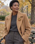The Orange pumpkin adds a compact bright detail to a camel coat and slate knit.