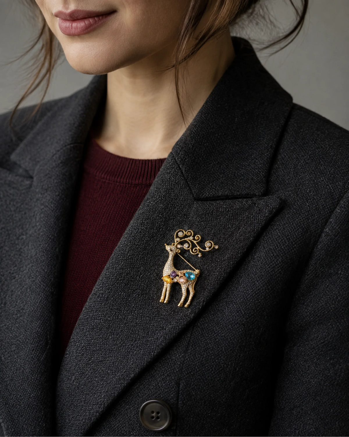 Close wearing view of Niva fastened inside a charcoal blazer lapel.
