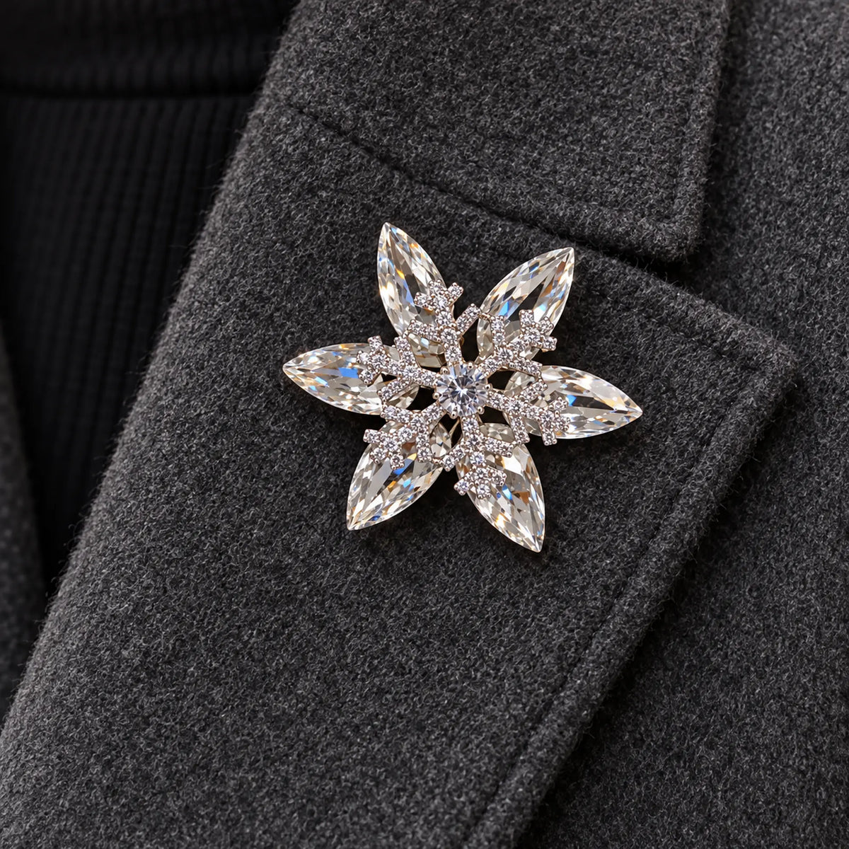 The complete silver-tone snowflake rests within one broad charcoal wool folded lapel.