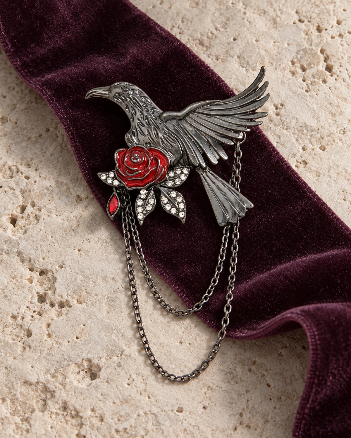Noctra brooch and two gunmetal chains on plum velvet and pale limestone