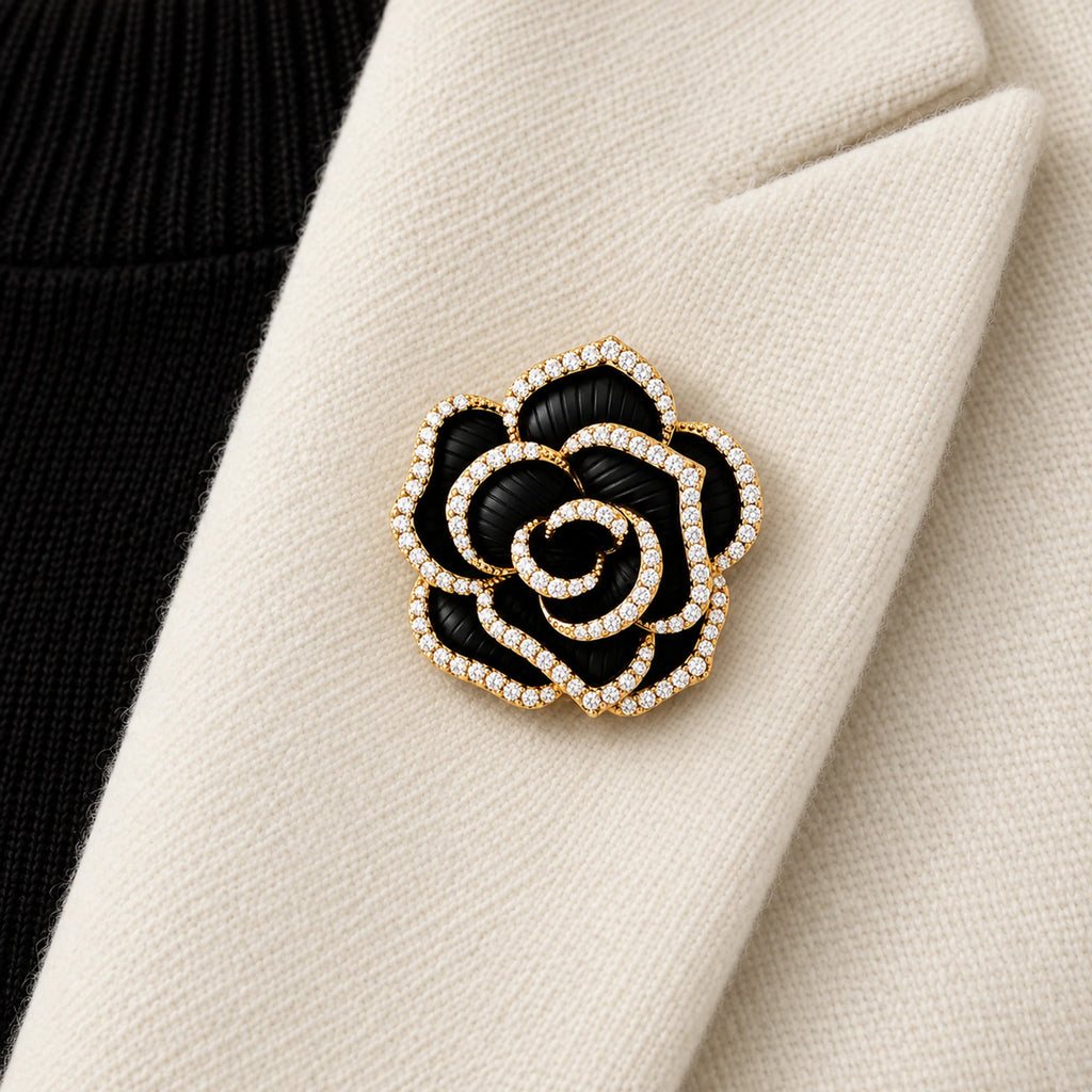 Noir black camellia brooch pinned inside an ivory folded blazer lapel in a local close view