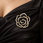 Noir black camellia brooch pinned to the draped fabric of a black evening dress in a local neckline close-up
