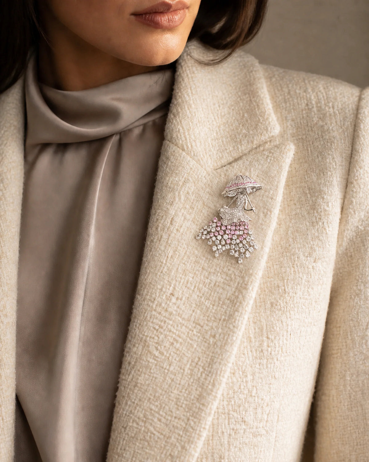 Noora parasol lady brooch at its true 5.3 by 7.1 centimetre scale on an ivory boucle lapel
