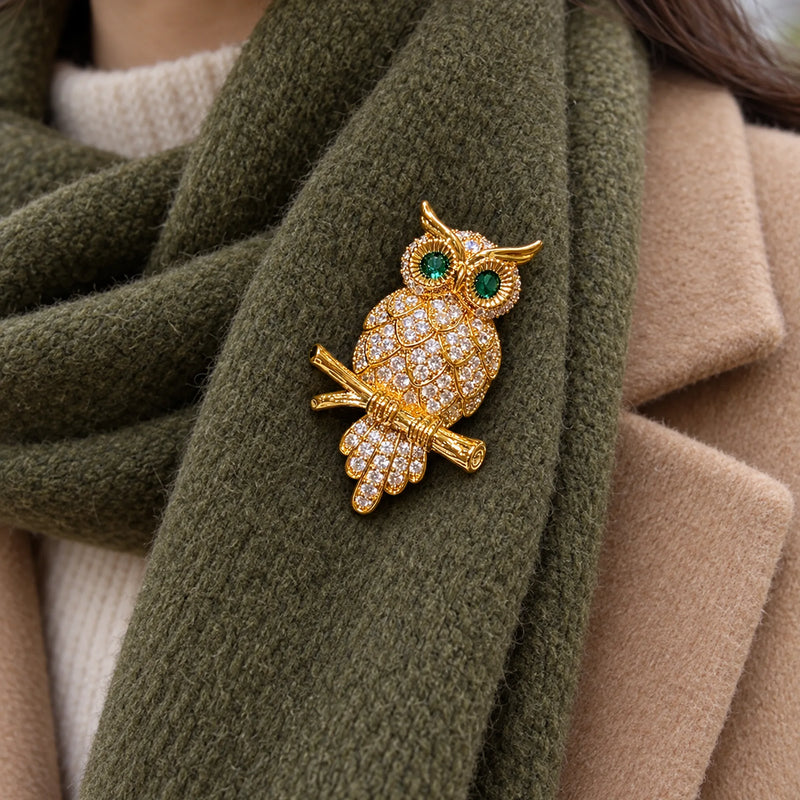 A doubled olive wool scarf supports the owl, branch and trailing feathers.