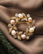 Macro view of the Olea brooch with natural freshwater pearls, clear zircon accents and gold-plated leaves
