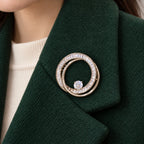 The small double loop rests within one broad forest-green wool lapel.