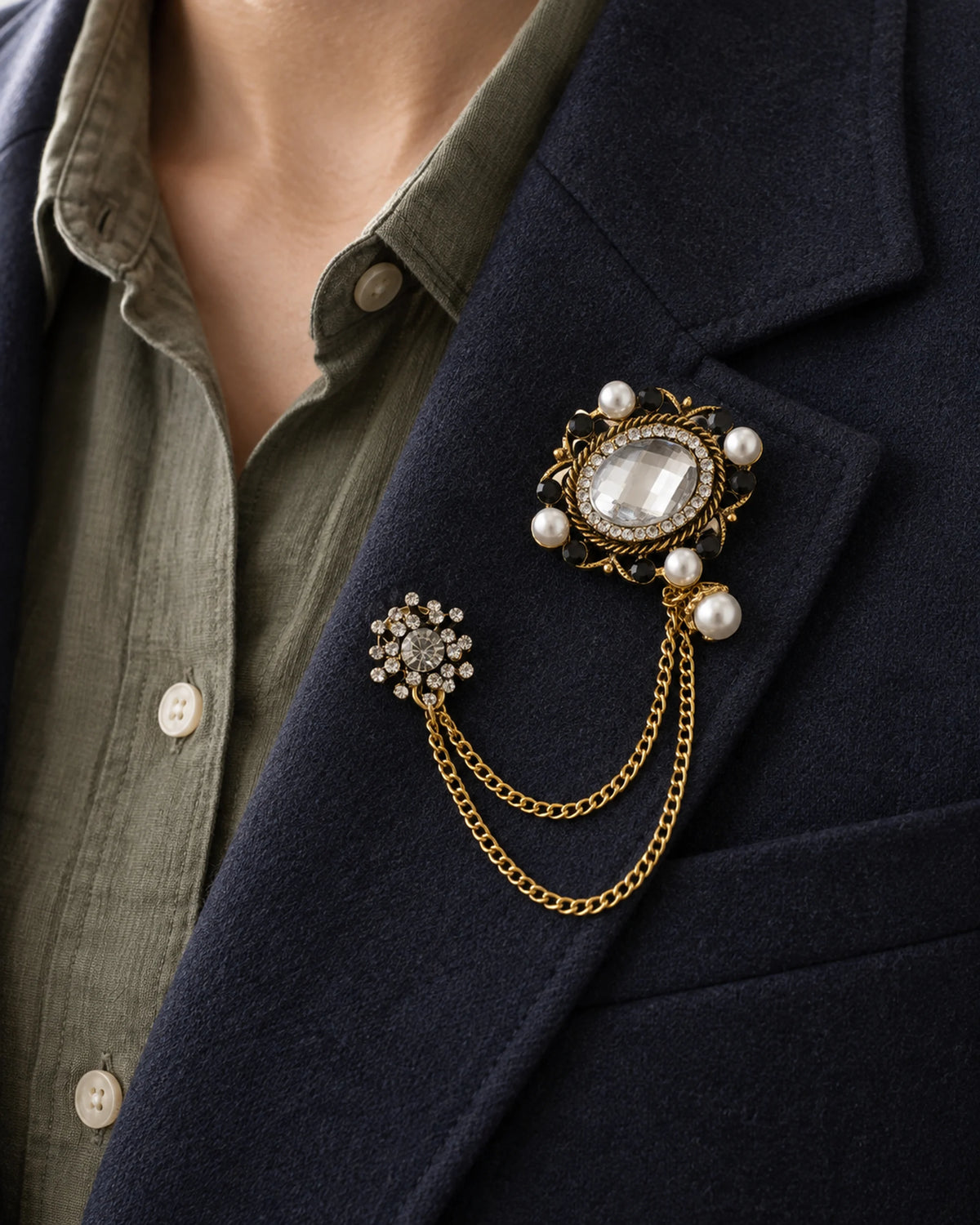 Ova Oval Beaded Lapel Chain Brooch in gold-tone finish; close wearing view on a structured lapel