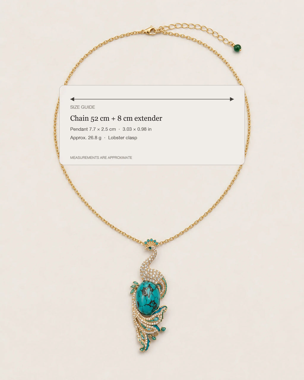 Pava Turquoise-Tone Peacock Pendant Necklace size guide showing a 52 cm chain, 8 cm extender, 7.7 by 2.5 cm pendant and 26.8 g weight.