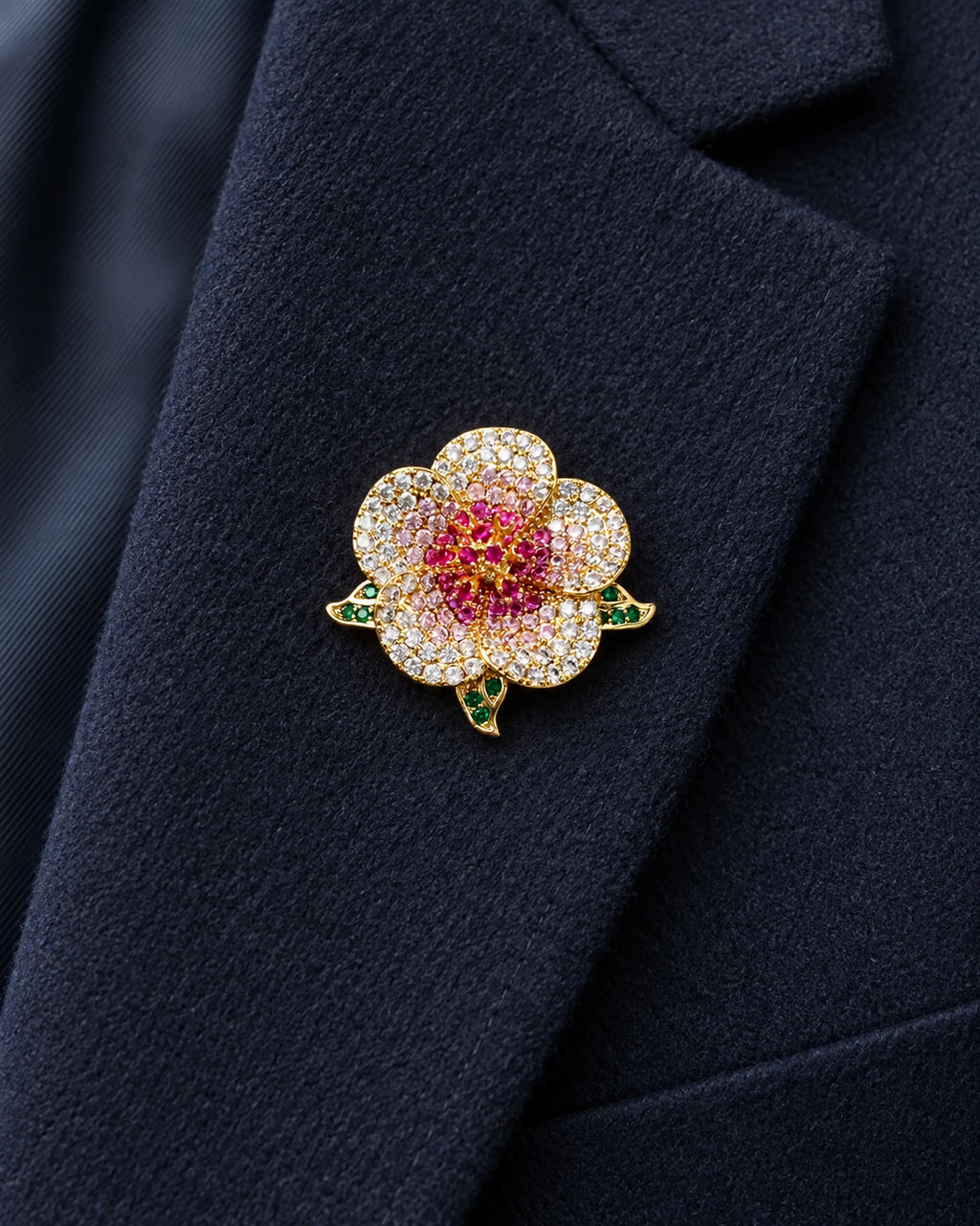 Pihla Pavé Flower Magnetic Brooch, Gold & Red worn on a navy jacket lapel, close view