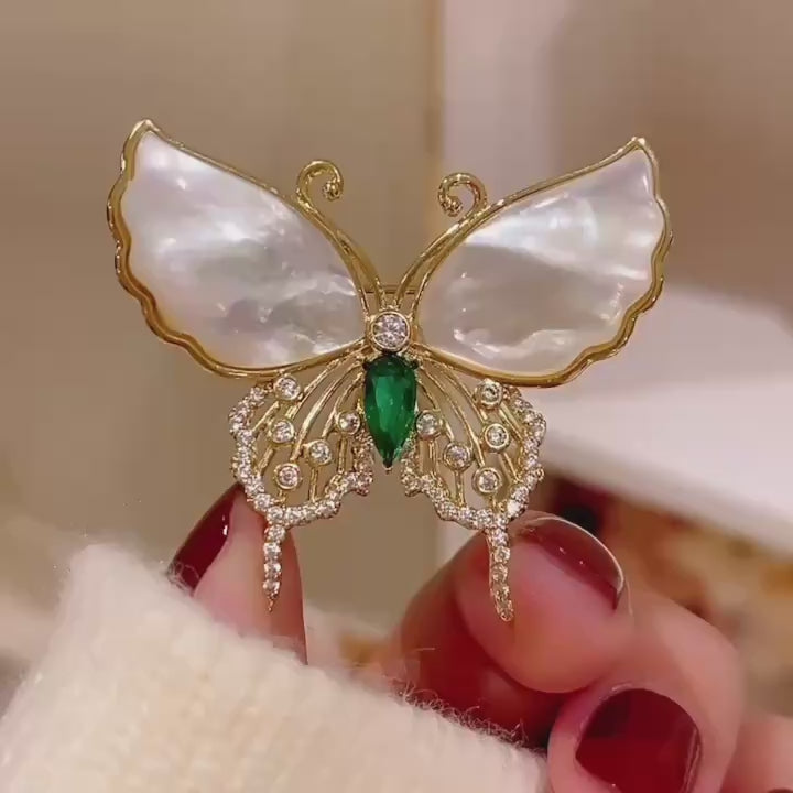 Elina Green Shell Butterfly Brooch in motion, showing its shell wings, green centre and crystal details.