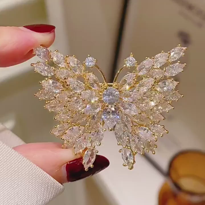 Eveli Marquise Crystal Butterfly Brooch in Gold shown from multiple angles in motion