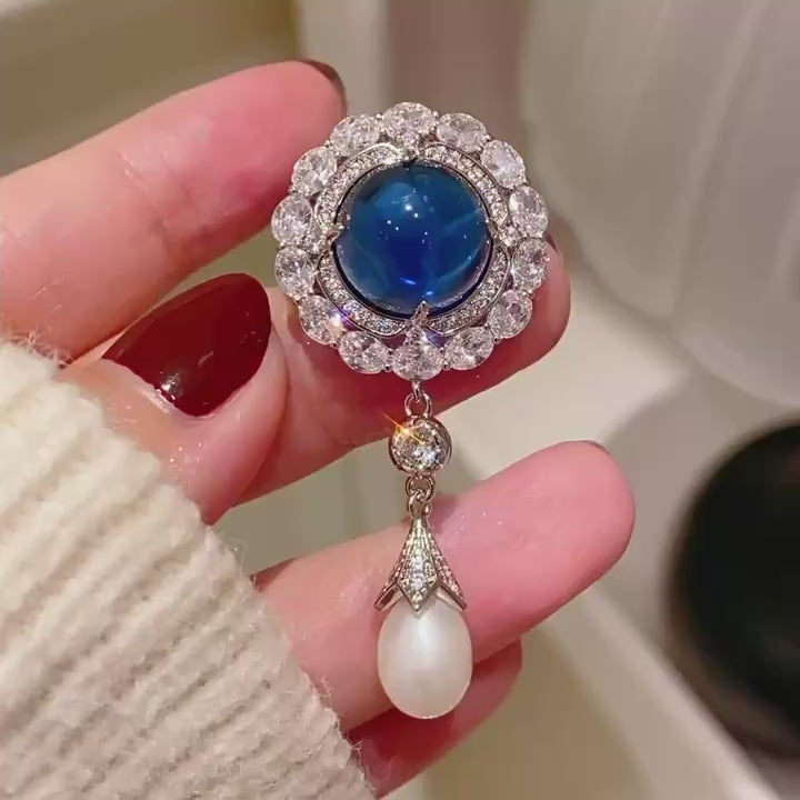 Silent detail film of Inari Blue Cabochon Pearl Drop Brooch.