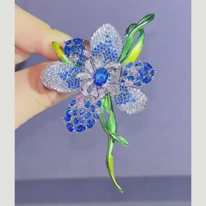 Malva Blue flower brooch turning in natural light; blue zircon accents, silver-tone setting and green enamel stem.