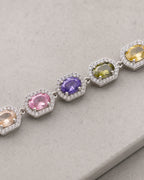 Macro view of an oval multicolor zircon center and its clear zircon halo on the Prisma bracelet.