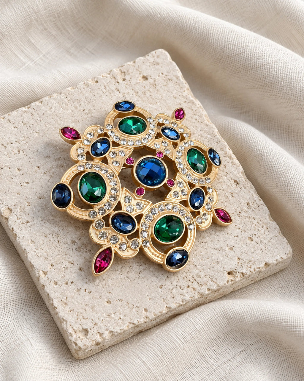 Ragna Multicolor Ornate Medallion Brooch — front view on a stone tile and ivory linen