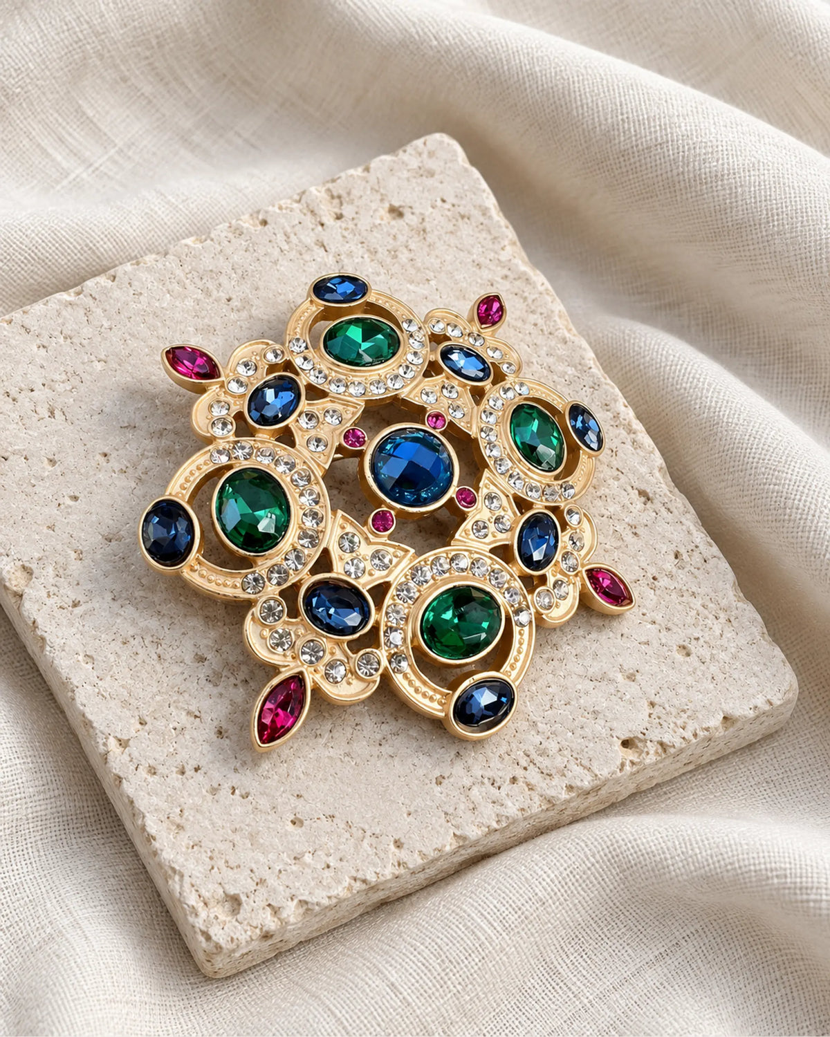 Ragna Multicolor Ornate Medallion Brooch — front view on a stone tile and ivory linen