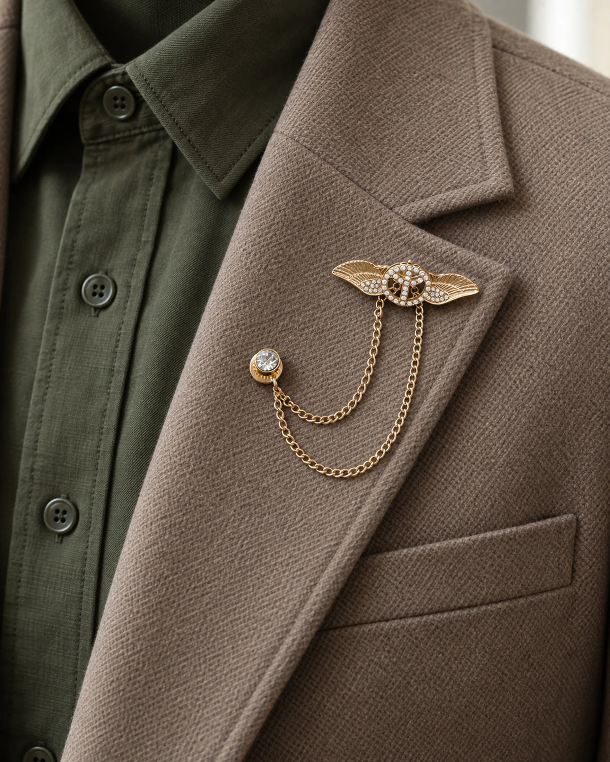 Rauha Winged Circle Lapel Chain Brooch in gold-tone finish — close wearing view on a jacket lapel