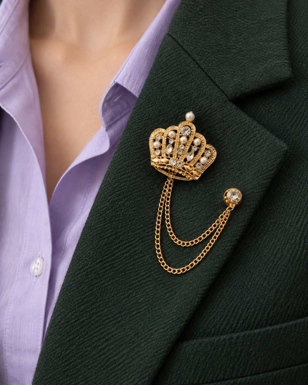 Regna Crown Lapel Chain Brooch in gold-tone finish; close wearing view on a structured lapel