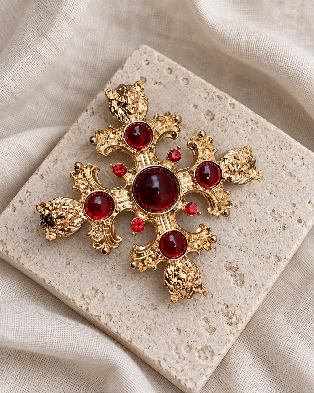 Rurik Red Lion Cross Brooch — front view on a stone tile and ivory linen