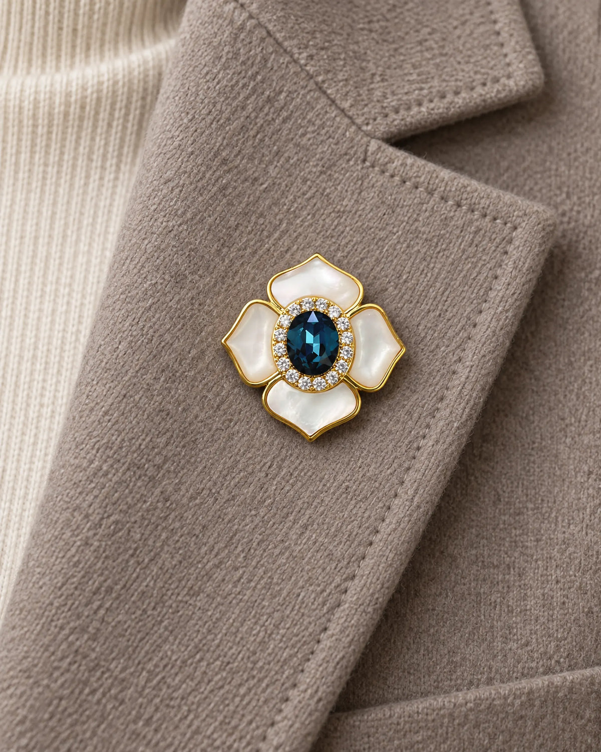 Saila Blue Shell Flower Magnetic Brooch, Gold & Midnight Blue worn on a taupe jacket lapel, close view