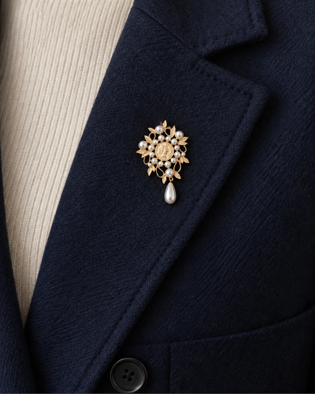 Signe Coin Medallion Drop Brooch — model wearing the brooch on a jacket lapel, close view