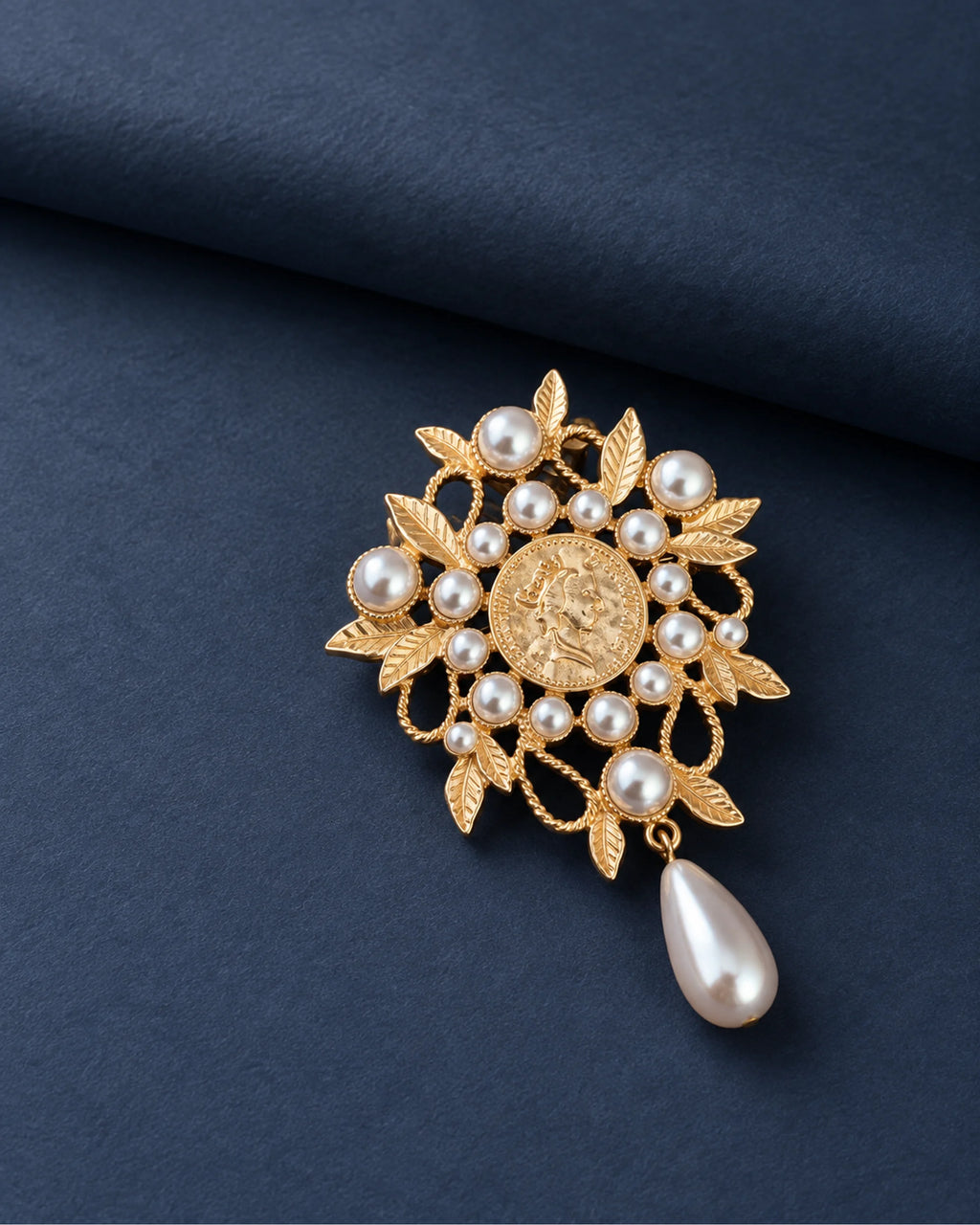 Signe Coin Medallion Drop Brooch — front display on folded slate-blue paper