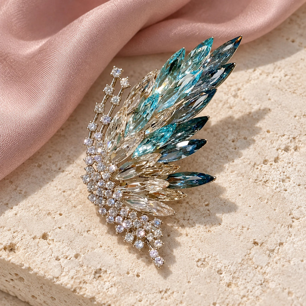 Complete Siiri Marquise Fan Butterfly Brooch resting on pale stone beside softly folded silk.