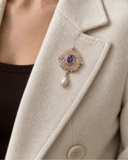 Siv Purple Face Medallion Brooch — model wearing the brooch on a jacket lapel, close view