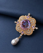 Siv Purple Face Medallion Brooch — front display on folded slate-blue paper