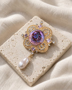 Siv Purple Face Medallion Brooch — front view on a stone tile and ivory linen