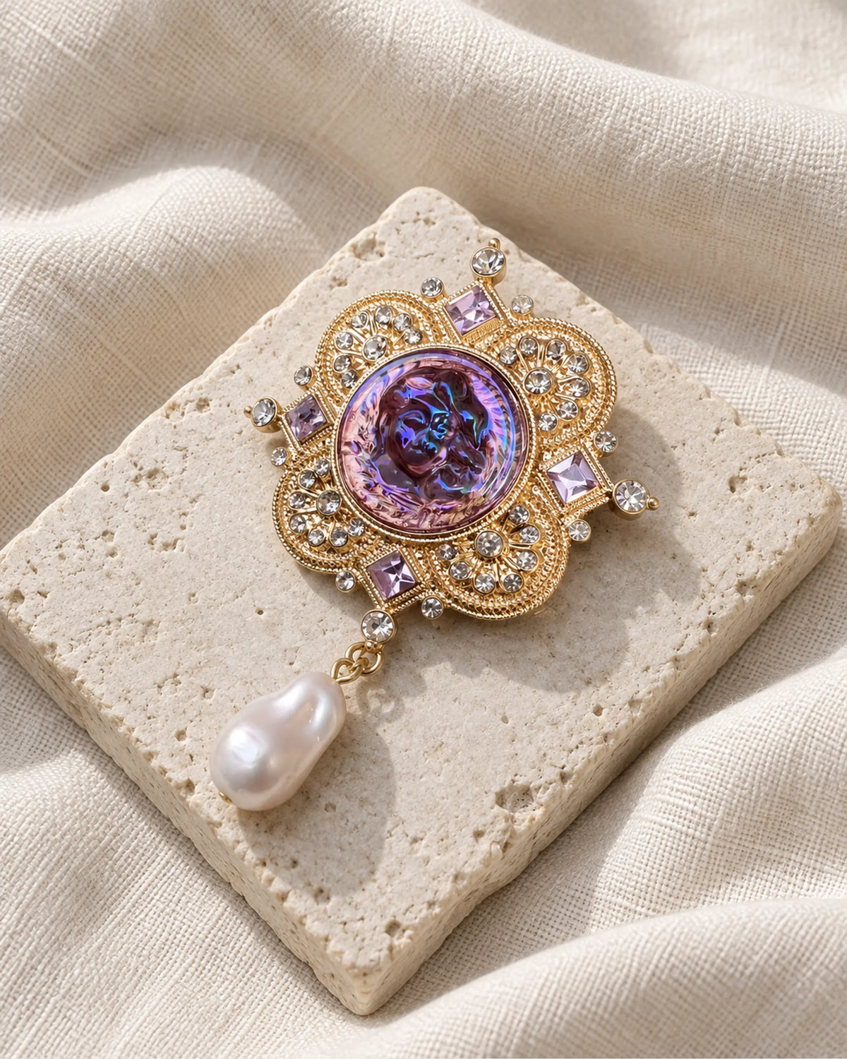 Siv Purple Face Medallion Brooch — front view on a stone tile and ivory linen