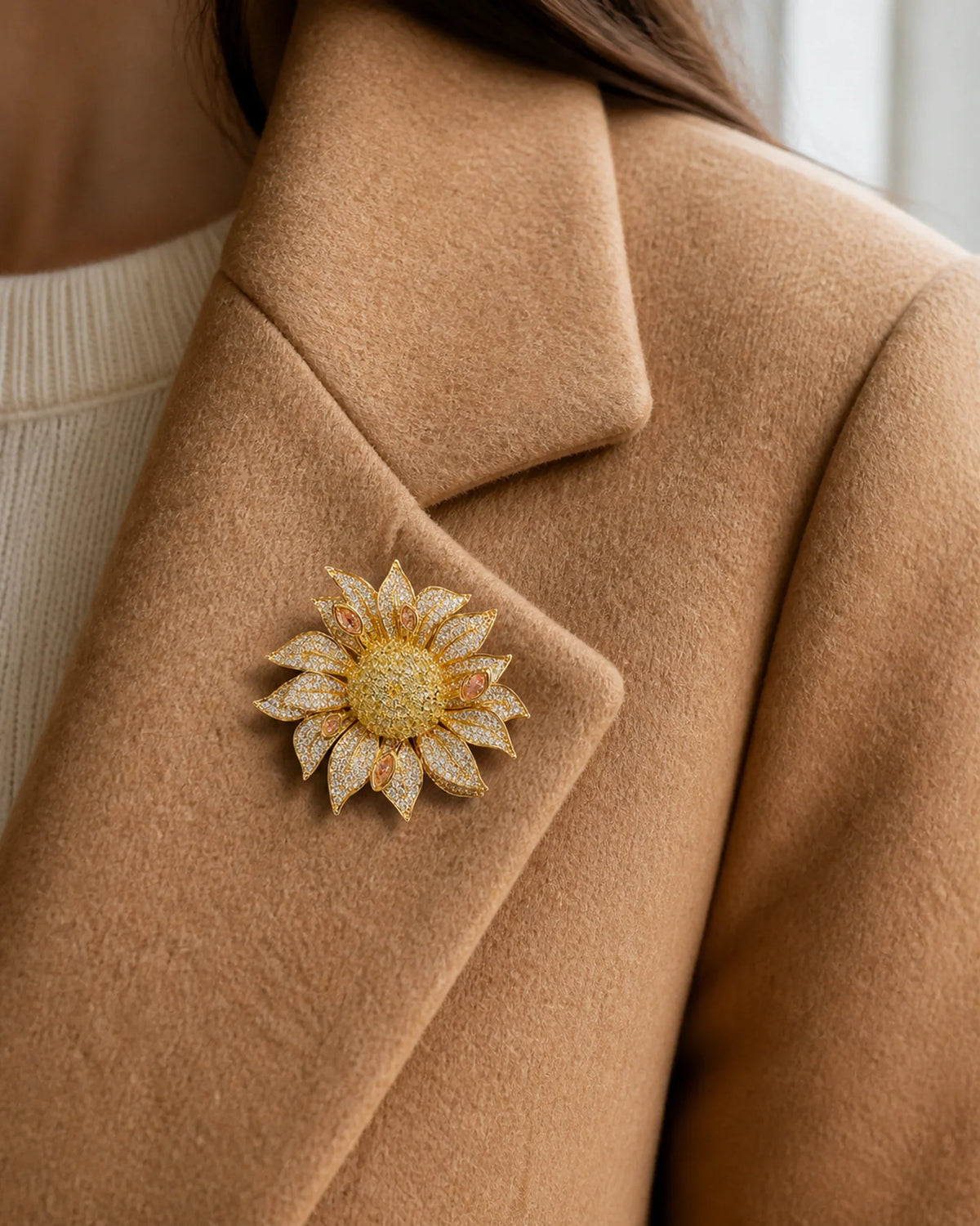Close view of the 5.5 centimetre Solvi Sunflower Brooch pinned fully to the broad folded lapel of a camel coat