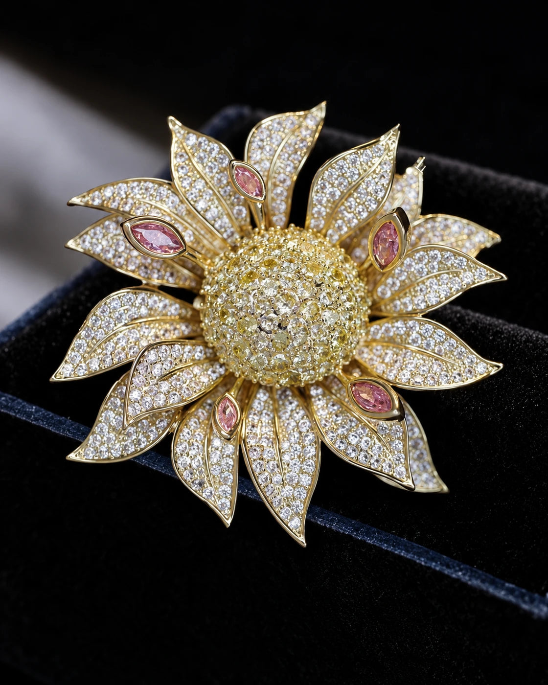 Macro view of the layered gold-tone petals, clear crystals and peach marquise accents of the Solvi Sunflower Brooch