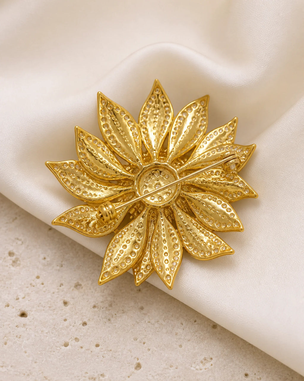 Back of the Solvi Sunflower Brooch showing its long pin stem, hinge and clasp on ivory silk