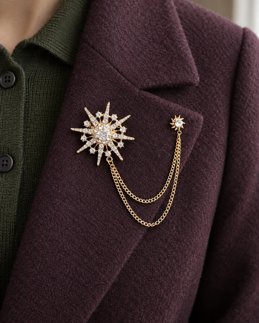 Stella Starburst Lapel Chain Brooch in gold-tone finish — close wearing view on a jacket lapel