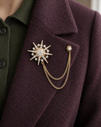 Stella Starburst Lapel Chain Brooch in gold-tone finish — close wearing view on a jacket lapel
