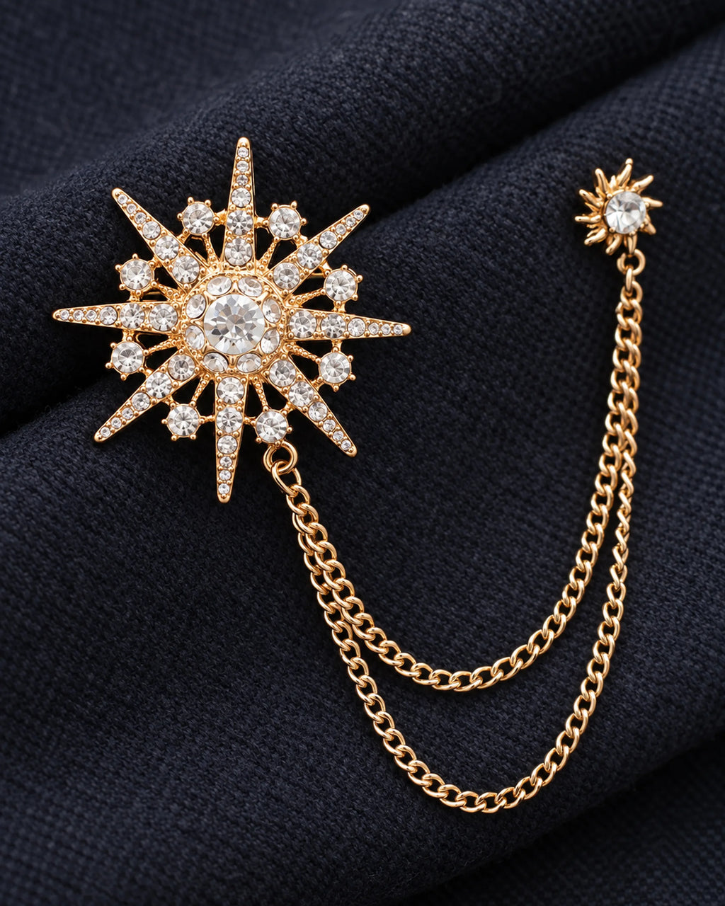 Stella Starburst Lapel Chain Brooch in gold-tone finish — detail study of the motif and chains