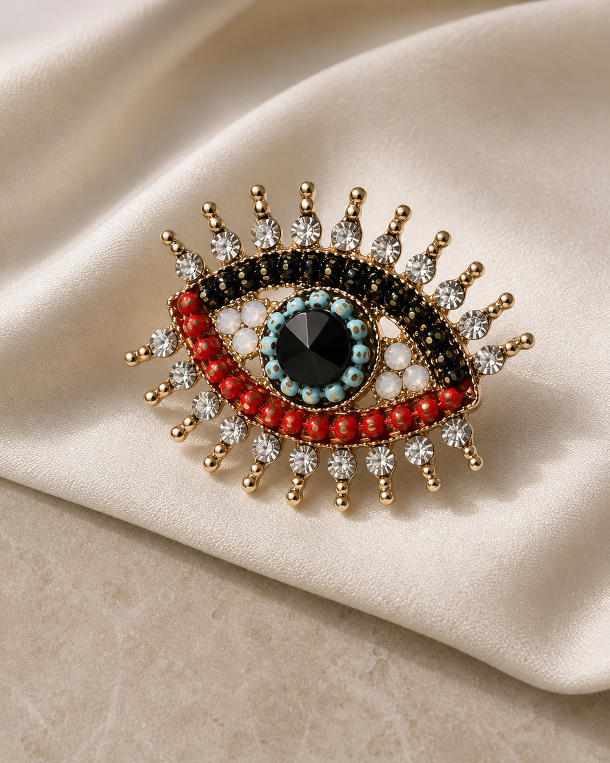 Angled studio view of the Suoja brooch showing its raised bead and crystal construction