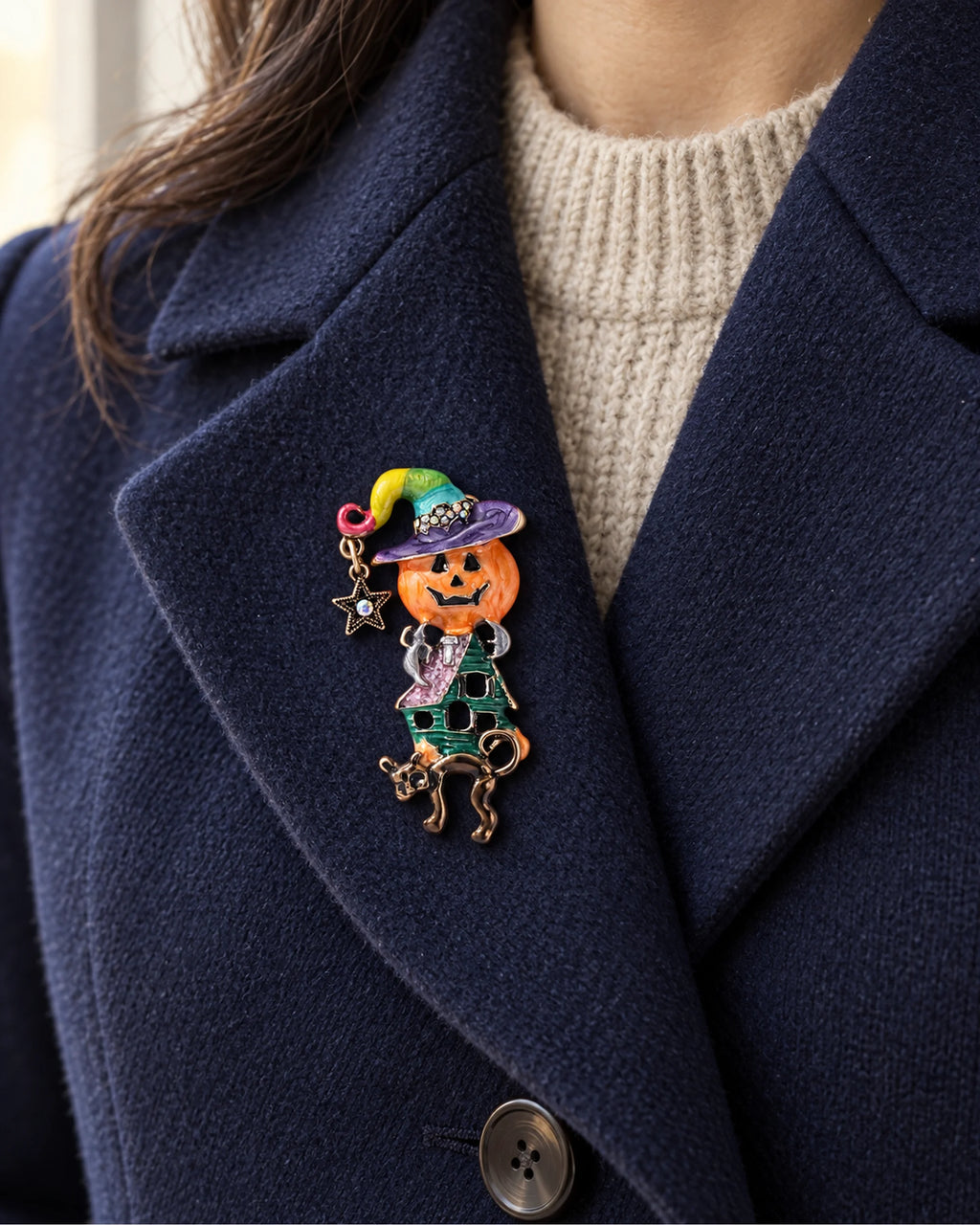 The complete witch, star and cat fit inside a broad navy lapel over an oatmeal knit.