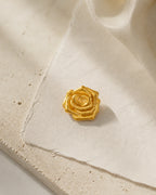 Taimi Mini Gold Camellia Brooch resting on ivory handmade paper and pale limestone in an original studio still life